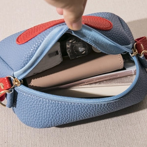 Blue lychee leather crossbody phone bag with red trim and spacious interior compartment