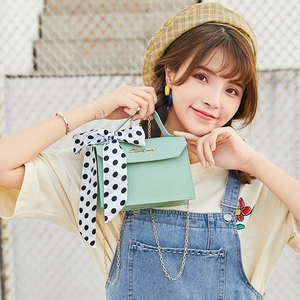Mint green square handbag with gold chain strap and decorative polka dot ribbon bow