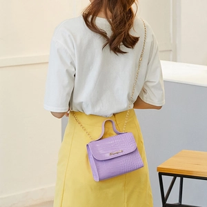 Purple crocodile pattern shoulder bag with gold chain strap worn by model