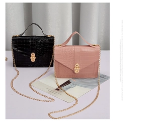 Detail of crocodile pattern shoulder bags with pearl metal clasp and gold chain straps