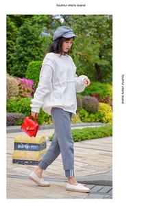 Street style shot of a red crocodile pattern chain bag with a pearl lock and white outfit