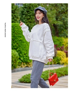 Close-up of white oversized sweatshirt paired with red crocodile pattern chain bag