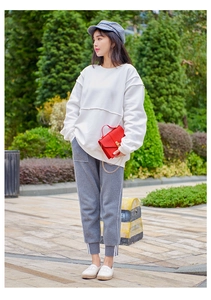 Outdoor lifestyle shot of a woman holding a red crocodile embossed chain strap handbag