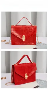 Detail of red crocodile pattern handbag with pearl lock and gold chain strap