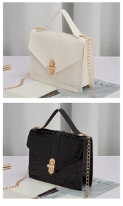 Detail of crocodile pattern leather bag with pearl metal buckle and chain strap