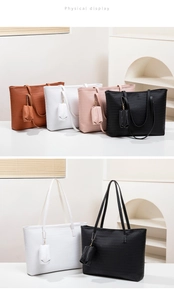Physical display of four woven tote bags in brown, white, pink, and black colors
