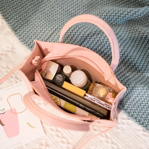 Pink crocodile pattern handbag showing interior space with phone and cosmetics