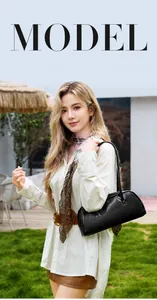 Detailansicht einer eleganten schwarzen Leder-Baguette-Tasche von einem Model im Freien