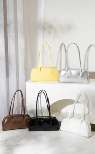 Detaillierte Kollektion glänzender Baguette-Taschen in fünf Farben auf minimalistischem Podest