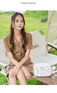 Detailed embroidery of pink flowers and green leaves on a white crossbody camera bag