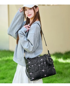 Close-up of quilted black tote bag with floral embroidery and detachable coin purse