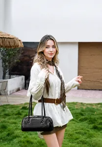 Minimalistische schwarze Baguette-Tasche an einem Modell vor modernem Außenhintergrund