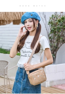 Detailed close-up of beige crossbody bag with delicate floral embroidery and logo