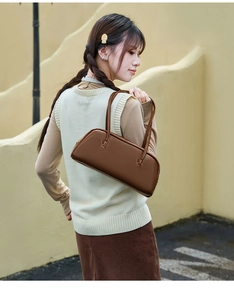 Detailansicht einer dunkelbraunen Baguette-Tasche im Vintage-Stil mit doppelten Henkeln
