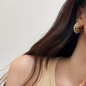 Gros plan sur des boucles d'oreilles créoles dorées vintage avec perles