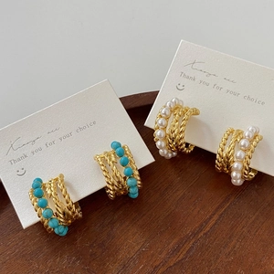 Boucles d'oreilles créoles dorées vintage avec turquoise et perles sur plateau