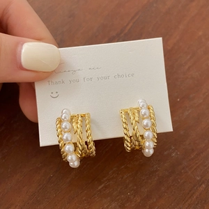 Détails de boucles d'oreilles créoles dorées vintage avec perles et texture torsadée