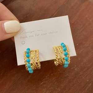 Boucles d'oreilles bohèmes dorées multicouches avec perles turquoise et métal torsadé
