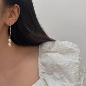 Boucles d'oreilles élégantes en perles d'eau douce avec pampilles dorées sur modèle