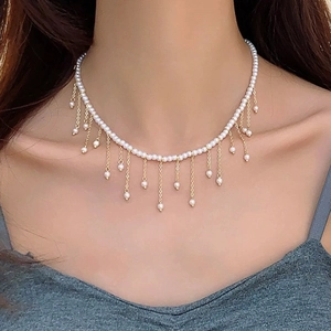 Close-up of a pearl choker necklace with gold fringe tassels on an Asian model