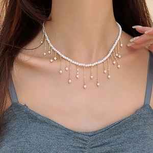 Elegant pearl choker necklace with gold tassel fringes on a female model