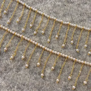 Macro detail of the golden tassel chain necklace featuring elegant white faux pearls