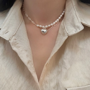 Détail du collier de perles d'eau douce baroques avec pendentif cœur argenté sur modèle