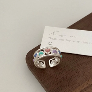 Close-up of adjustable open ring with colorful enamel hearts and matte silver finish