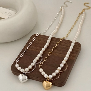 Collier de perles d'eau douce baroques avec pendentifs cœur en finitions or et argent