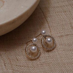 Detail of French vintage gold earrings featuring geometric zircon circles and white pearls