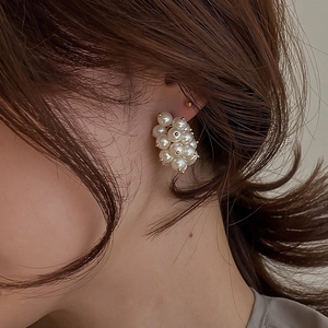 Elegant French style cluster pearl stud earrings with golden base on female model