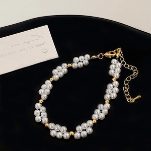 Détail d'un bracelet de perles double rang avec billes dorées et fermoir mousqueton réglable