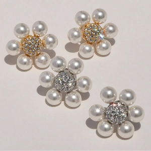Detail of floral pearl earrings with shimmering crystal center in gold and silver plating