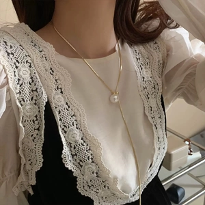 Close-up of minimalist gold snake chain necklace with large round white pearl pendant