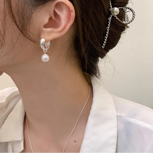 Elegant geometric pearl drop earrings in silver finish on model for a minimalist jewelry look