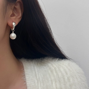 Close-up of minimalist silver geometric earring with a 10mm round white pearl pendant