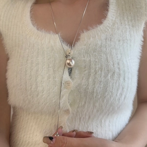Detailed view of adjustable Y-shaped pearl necklace on a soft white knit sweater