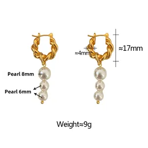 Detail of twisted gold hoop earrings with cascading 8mm and 6mm white pearls