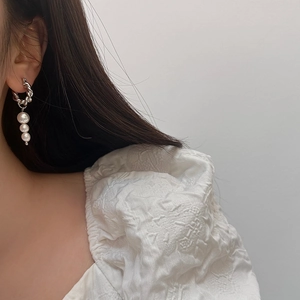 Silver twist hoop earrings with triple pearl pendants worn on model for daily style