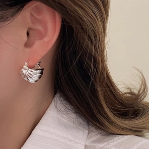Detail view of French retro striped silver earring with an elegant white pearl inlay