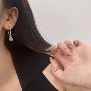 Detail of gold tassel drop earrings with knot pendant on model showing length and fit
