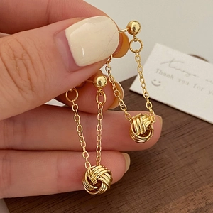 Elegant geometric gold tassel earrings featuring long chains and hollow sphere pendants