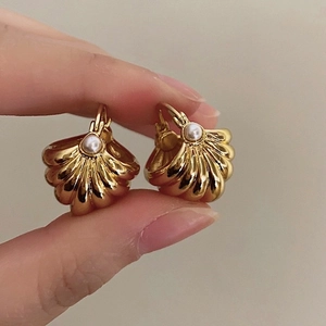 Detailed close-up of French vintage striped shell earrings with pearls and gold finish