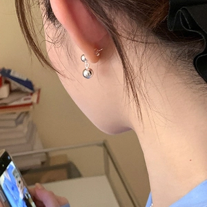 Minimalist double silver ball earrings with high-polish finish on a female model