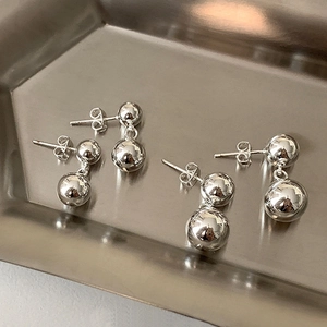 Detail of silver double ball drop earrings with polished mirror finish in two pairs