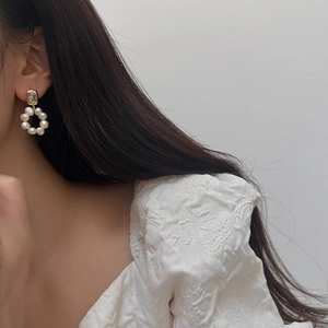 Detailed view of elegant freshwater pearl hoop earrings with zircon stud on model