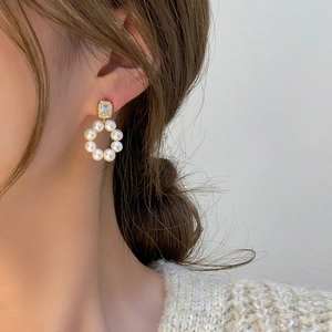 Elegant freshwater pearl hoop earrings with zircon studs shown on a female model