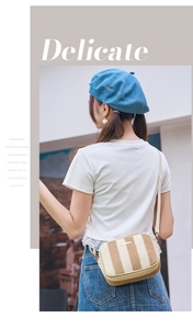 Detailed view of striped woven straw camera bag with elegant gold hardware and leather strap