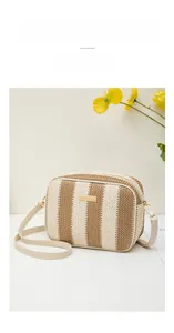 Close-up of woven straw camera bag with white and brown stripes and gold metal hardware