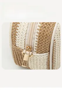Close-up of smooth gold metal zipper and fine dual-tone woven texture of straw bag